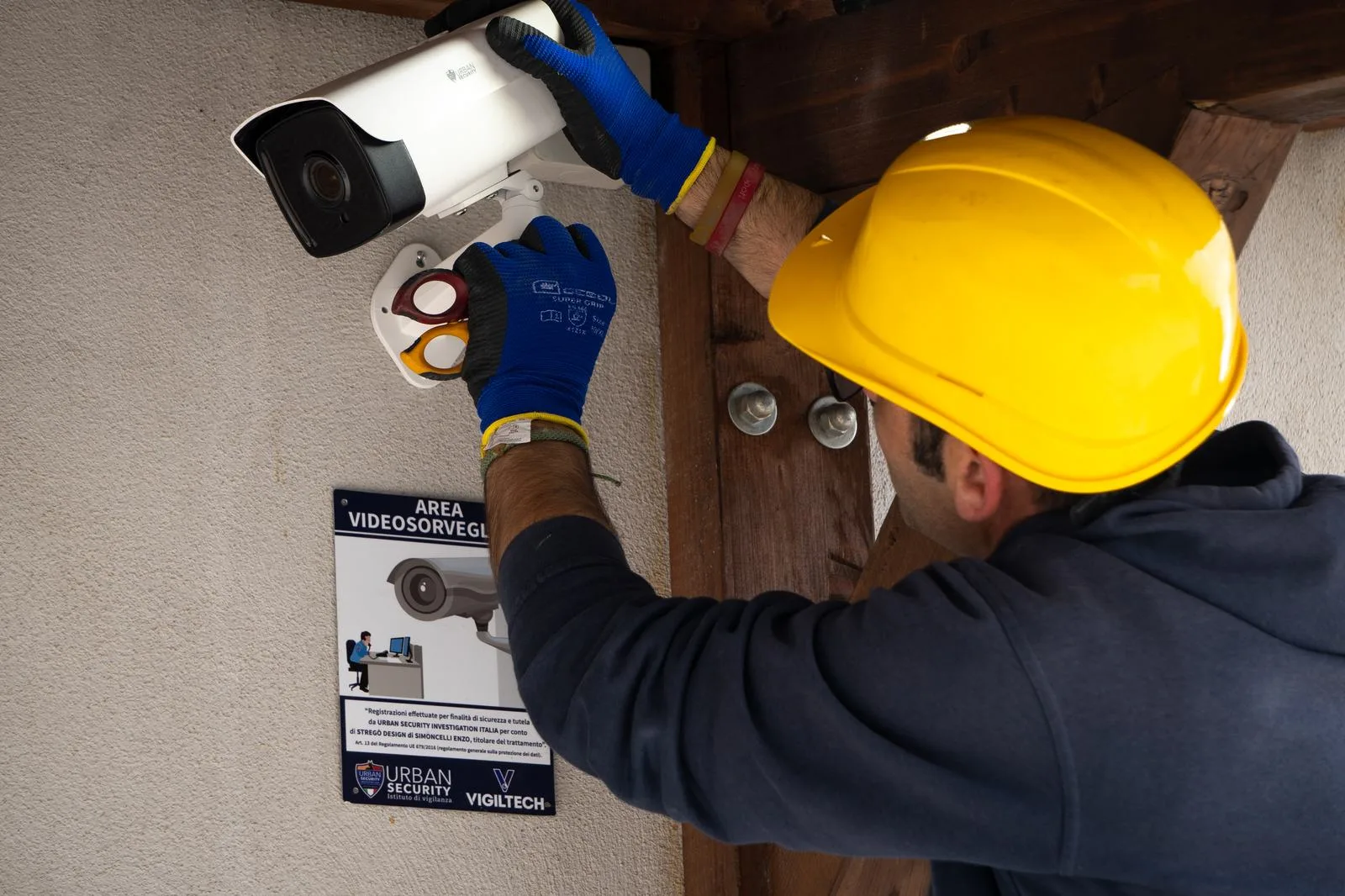 Tecnico Urban Security durante l'installazione e la configurazione di una telecamera di videosorveglianza professionale